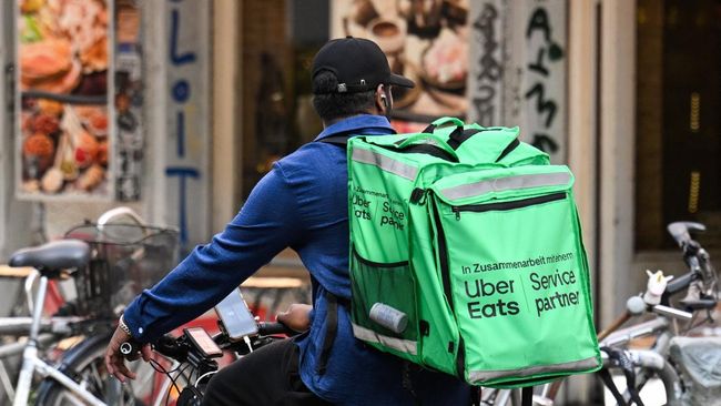 seorang pengendara sepeda pengantar makanan dengan tas punggung uber eats mengendarai sepeda di berlin jerman pada 16 juli 202 1786599850705 169