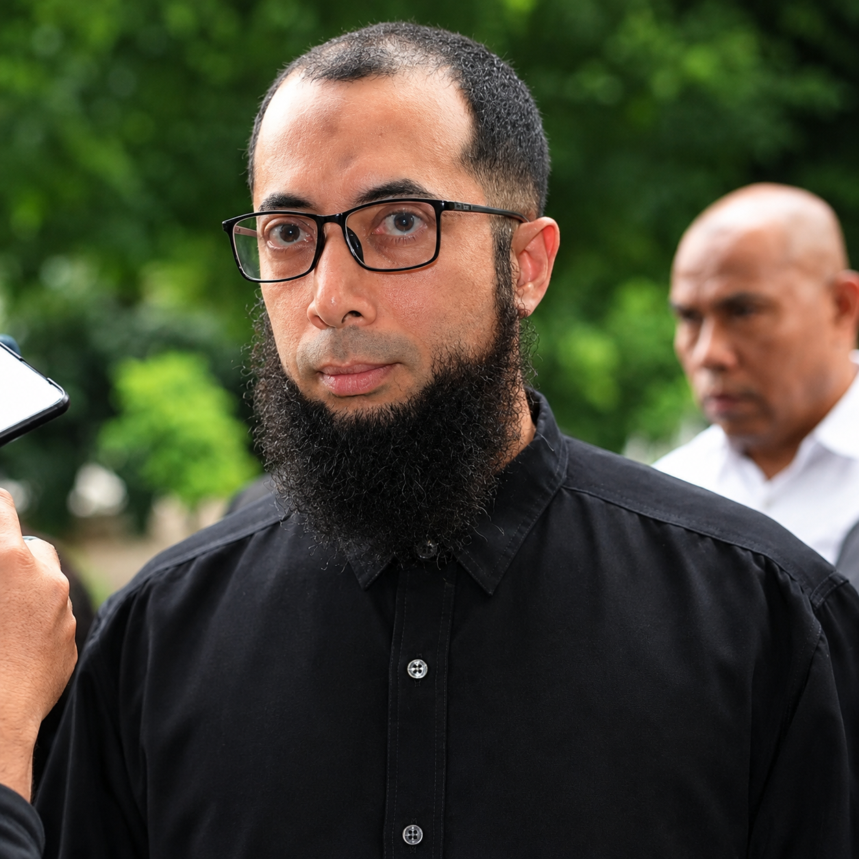 potret pria berjanggut di tengah hijau